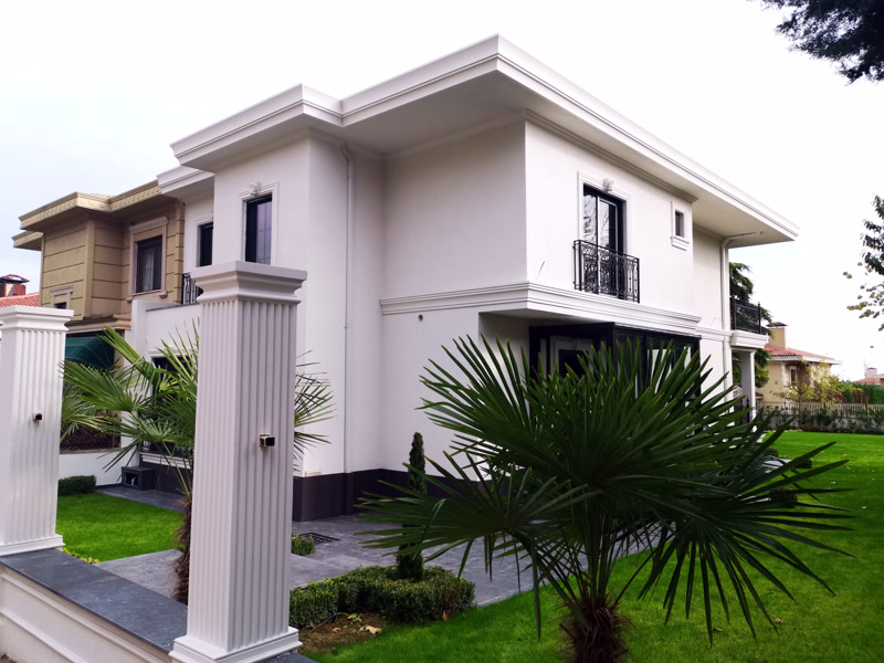 Beyaz villa dış cephesinde yivli poliüretan pilaster sütun ve pencere söve profillerinin modern uygulanışı.