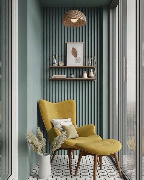 Yeşile boyanmış dikey poliüretan duvar paneli ve sarı berjer içeren kapalı balkon okuma köşesi dekorasyonu.
