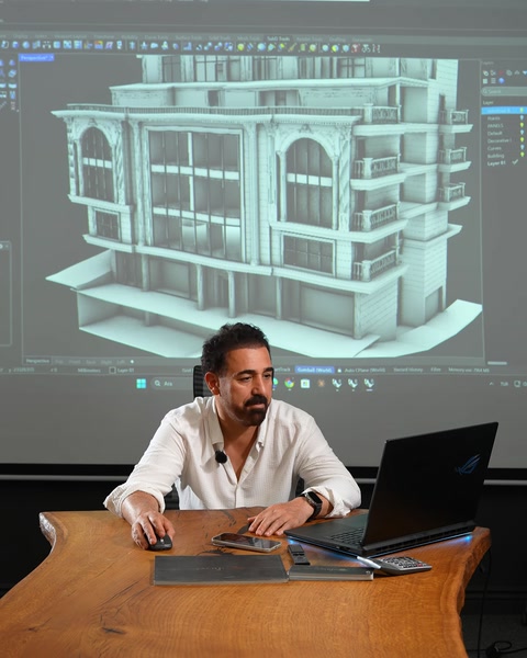 Masada oturan sunucu ekrandaki 3D bina modelini anlatıyor