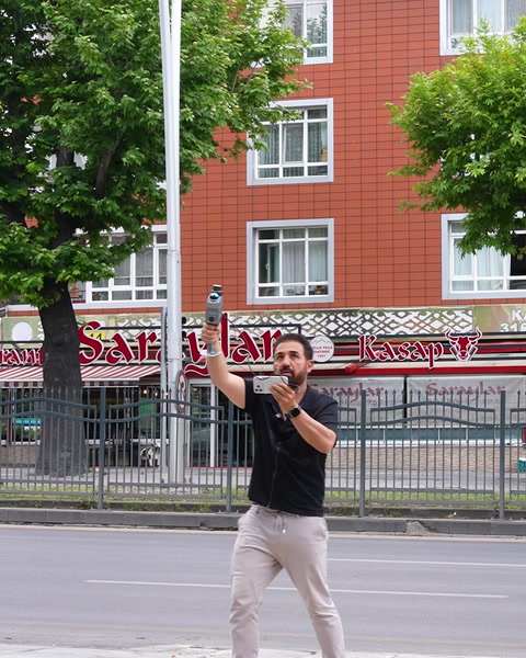 Sunucu cadde kenarında ayakta konuşarak anlatım yapıyor