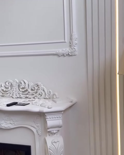 Kabartmalı duvar çıtalarıyla bütünleşen klasik şömine tasarımı