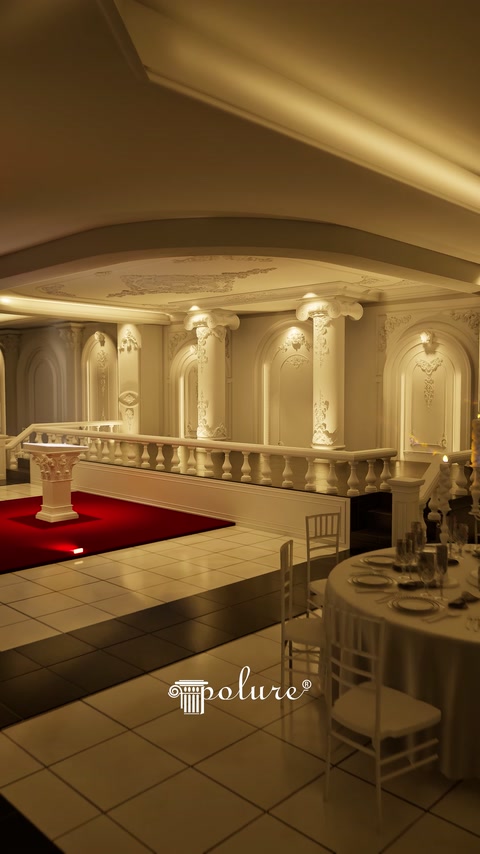 Aydınlatılmış salon köşesinde sütun dizisi ve dekoratif korkuluk uzanıyor