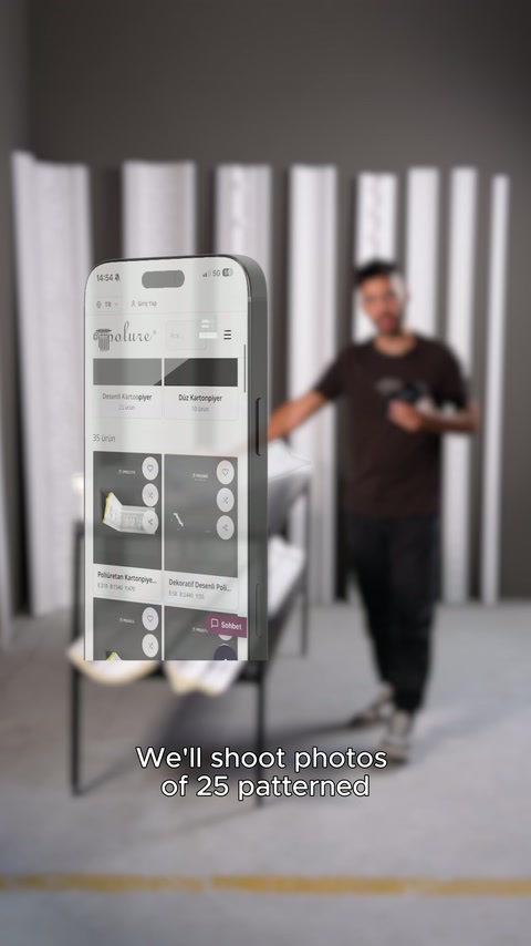 Telefon ekranındaki ürün sayfası, stüdyodaki sunucunun önünde gösteriliyor
