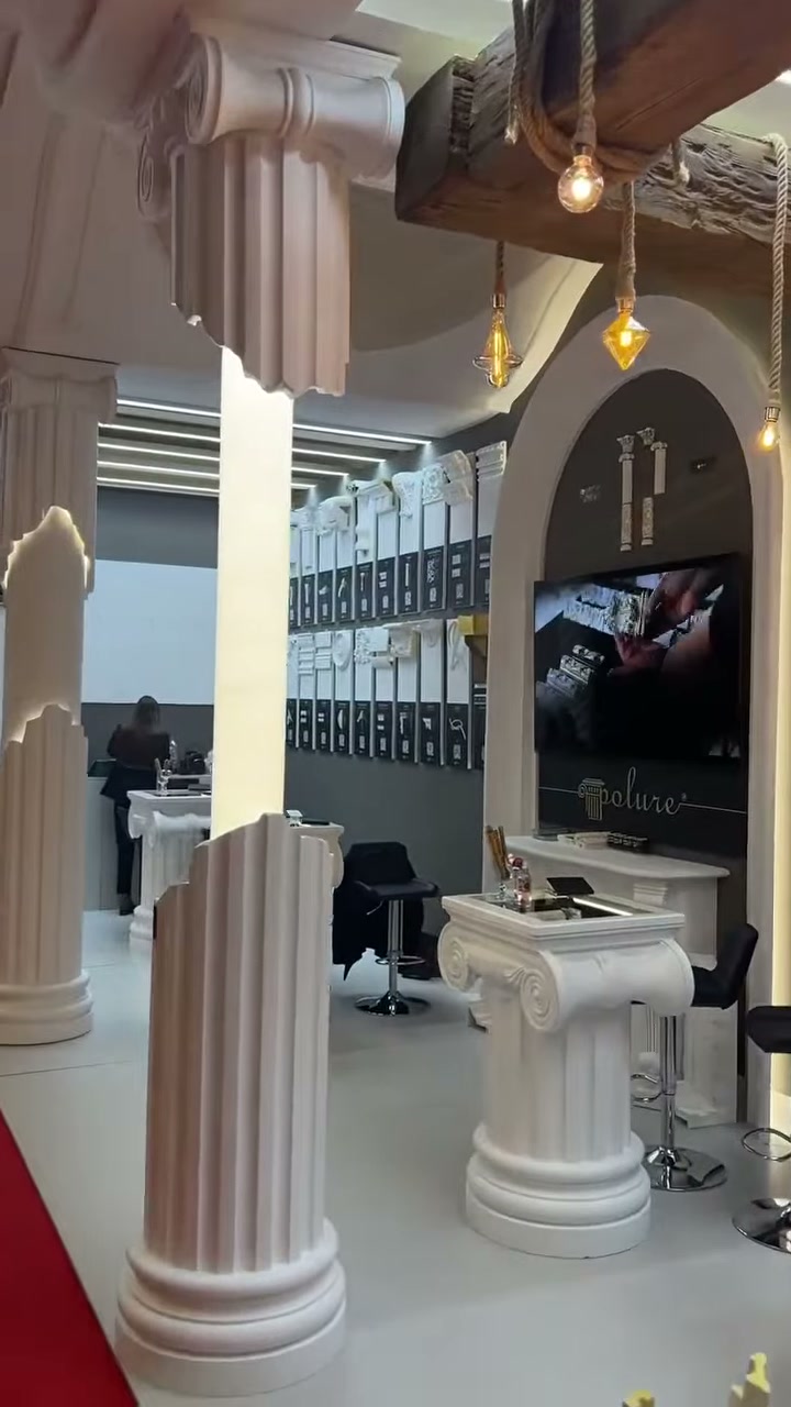Antik başlıklı sütunlar, kemerli duvar bölümü ve teşhir masası görülüyor