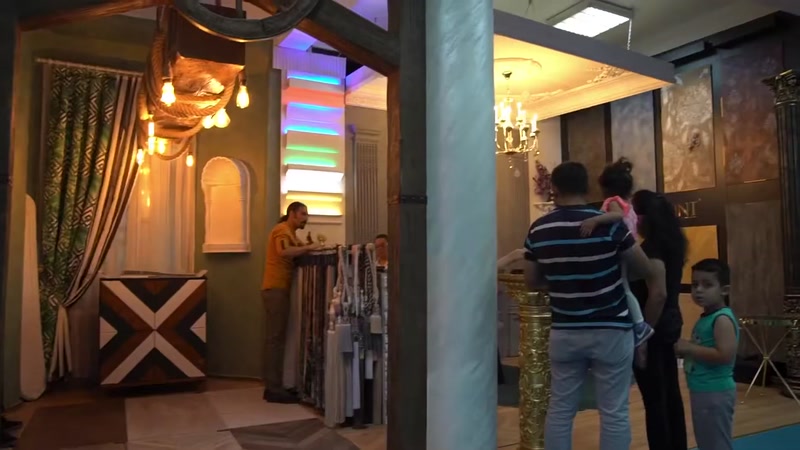 Renkli aydınlatmalı sütunlar ve tavan silmesi sergi alanında görünüyor