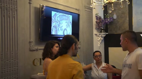 Şömine uygulaması önünde ziyaretçiler dekoratif duvar düzenini değerlendiriyor