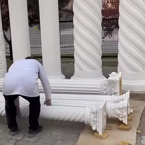 Usta, zemindeki işlemeli sütun başlığı parçasını kontrol ediyor