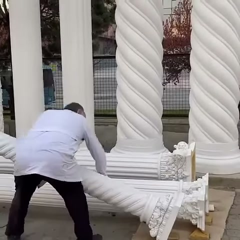 Usta, uzun sütun parçasının ucunu iki eliyle tutuyor