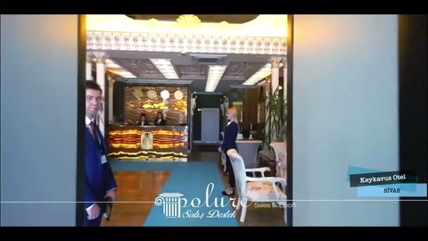 Açık kapıdan resepsiyon bankosu ve desenli lobi tavanı görünüyor