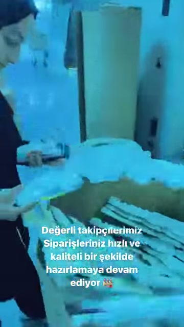 Çalışan, tezgâhtaki kıvrımlı poliüretan süslemelerin yanında inceleme yapıyor.