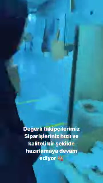Görevli, beyaz süsleme parçalarının bulunduğu tezgâha doğru yöneliyor.