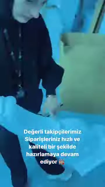 Görevli, çalışma masasındaki küçük poliüretan elemanlardan birini tutuyor.