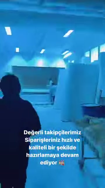 Çalışan, büyük tezgâhların bulunduğu üretim salonunda ilerliyor.