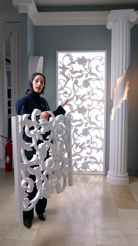 Beyaz oyma panel örneği, sütunlar arasındaki ışıklı uygulama önünde tanıtılıyor