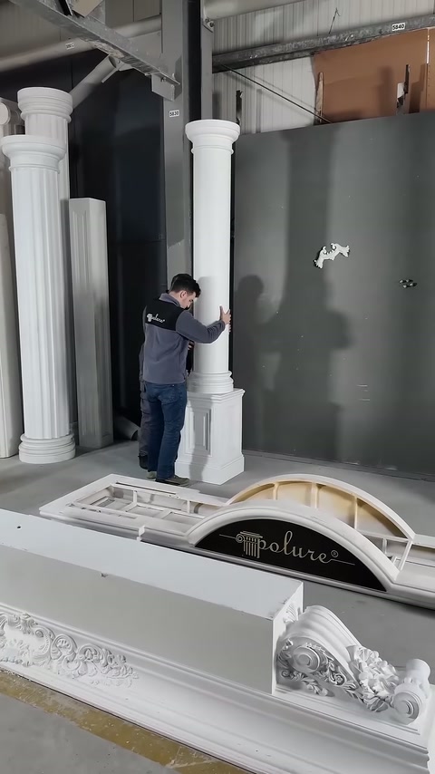Çalışan, dikey sütunun kaideyle hizasını elleriyle kontrol ediyor.