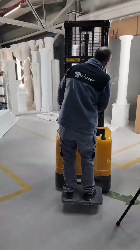 Görevli, sarı kaldırma aracını montaj alanında yönlendiriyor.