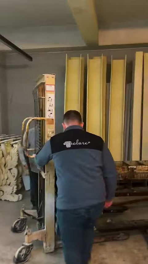 Çalışan, dik duran parçaların yanında taşıma arabasını hareket ettiriyor.