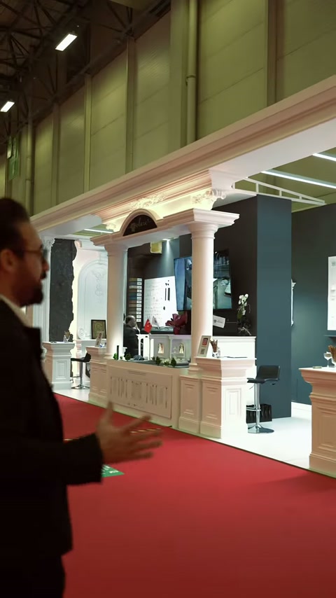 Sütunlu stand cephesi, fuar koridorundan geniş açıyla izleniyor