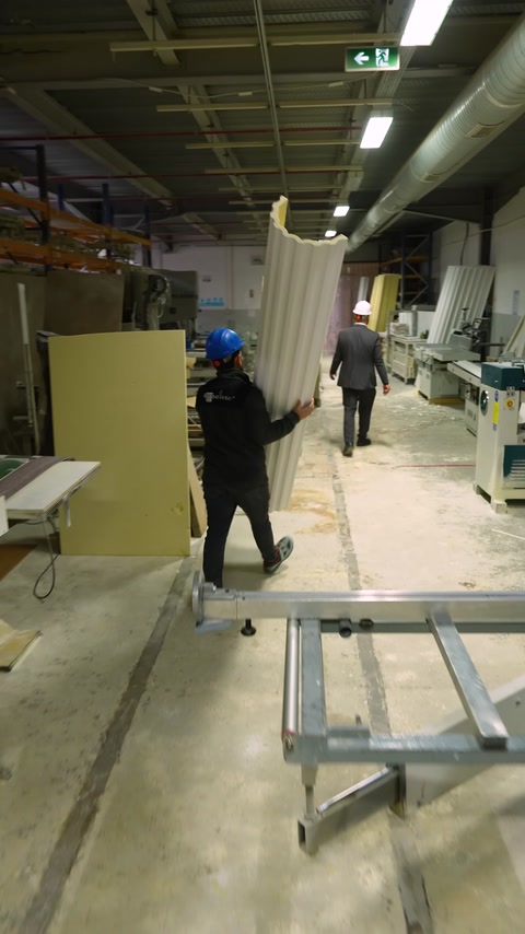 Büyük dekoratif profil fabrika içinde iki çalışanla taşınıyor