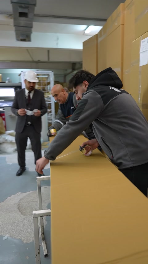 Uzun karton kutu paketleme tezgâhında bantlanarak kapatılıyor