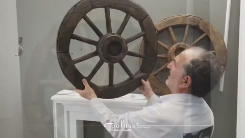 Sunucu koyu renkli at arabası tekerini şömine üzerinden kaldırıyor