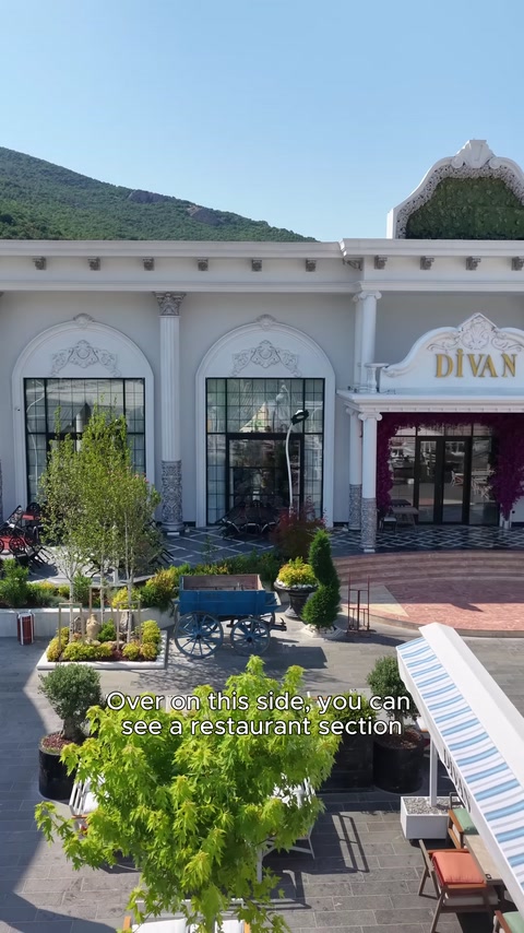 Restoran cephesinde kemerli pencereler, sütunlar ve havuz düzeni bulunuyor