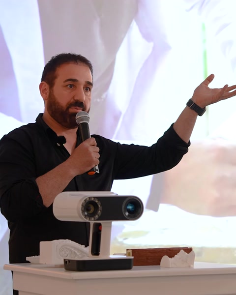 Konuşmacı masadaki projeksiyon cihazıyla sunum yapıyor
