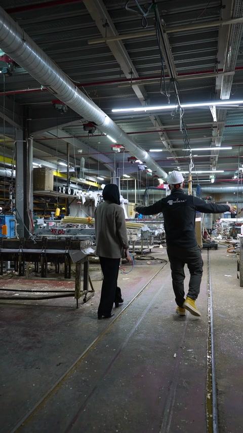 Geniş üretim hattı ve atölye düzeni ekip eşliğinde görülüyor