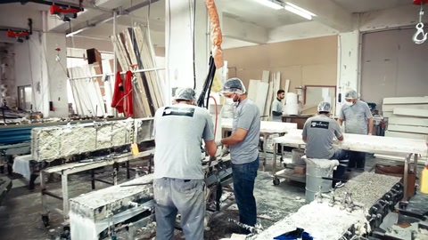 Atölyenin orta bölümünde ustalar farklı tezgâhlarda üretim yapıyor.