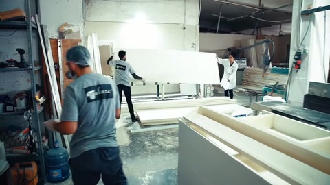 Usta, büyük kavisli beyaz parçayı üretim sehpasında kontrol ediyor.