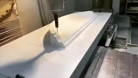 CNC tezgâhı poliüretan levha üzerinde kavisli söve formu işliyor.