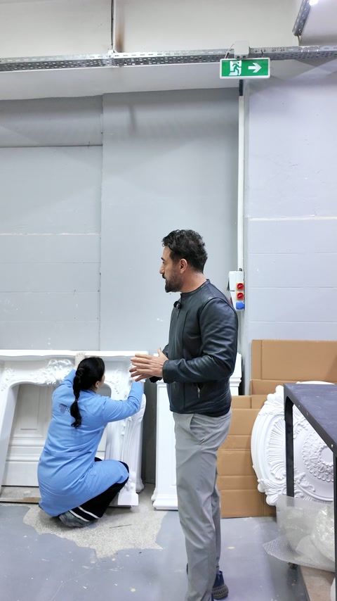 Çalışan, beyaz dekoratif parçaya paketleme öncesi rötuş uyguluyor