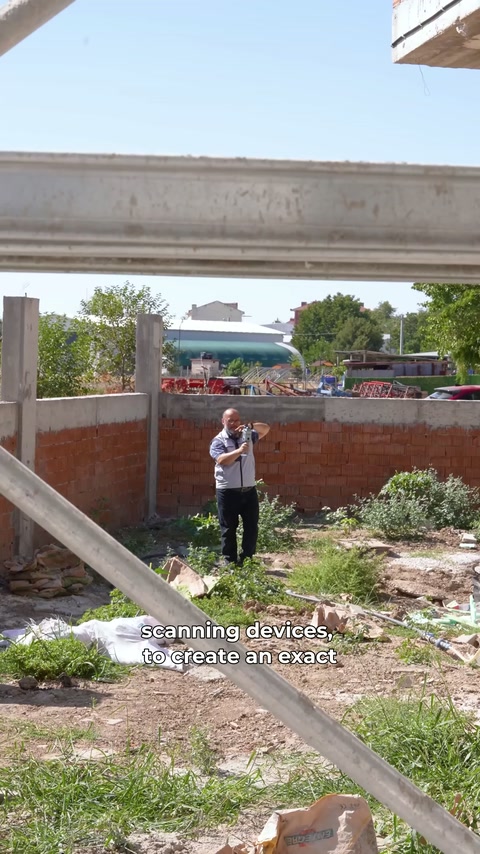 Bahçedeki görevli elindeki tarayıcıyla yapının dış hatlarını kaydediyor.