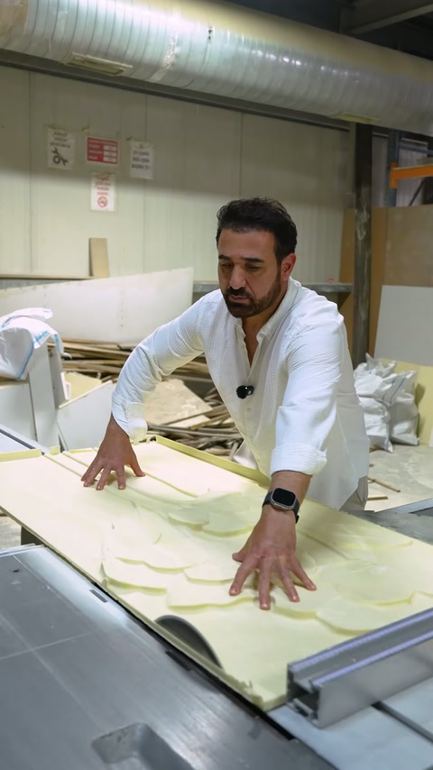 Kabartmalı pano CNC tezgâhında iki elle dikkatlice yönlendiriliyor.