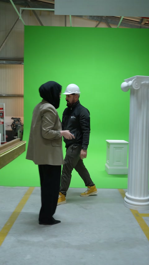 İki kişi eğik tutulan yivli sütun üzerinde değerlendirme yapıyor