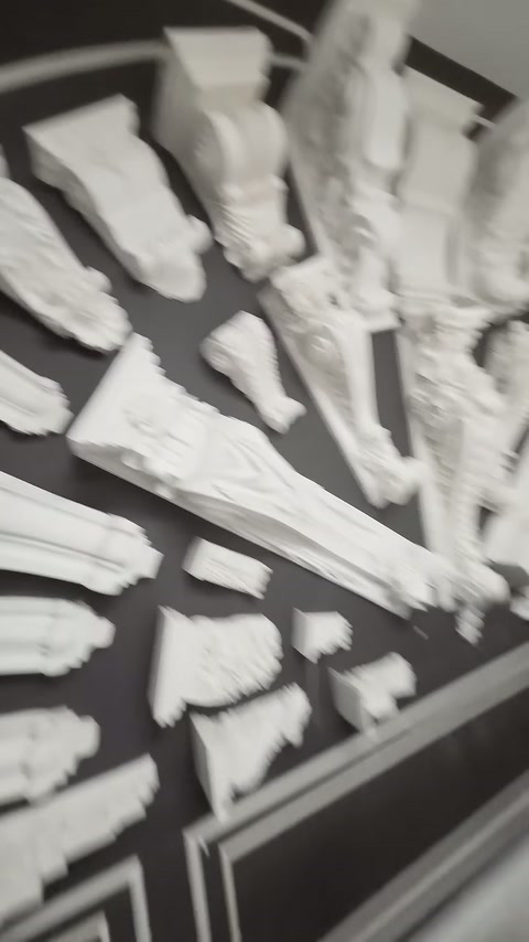 El, beyaz kabartmalı bordürün yaprak desenli yüzeyine dokunuyor.