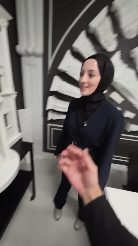 Sunucu, cephe maketinin yanında dekoratif elemanları anlatarak gösteriyor.
