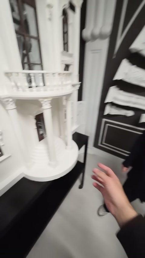 Beyaz bina maketinde balkon korkuluğu, sütunlar ve pencere çerçeveleri görülüyor.