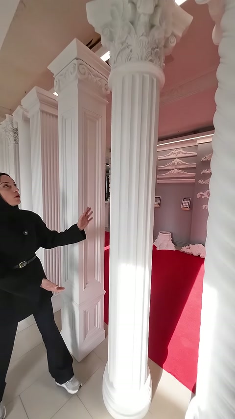 Korint başlıklı yivli sütunlar, pembe showroom bölümünde art arda sergileniyor.