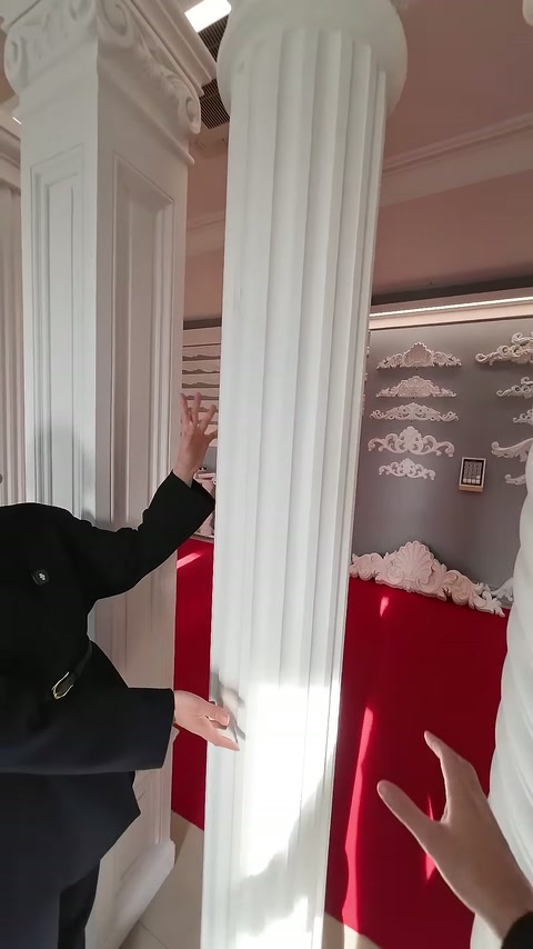 Sunucu, iki yivli sütunun uzun gövdelerini eliyle karşılaştırıyor.