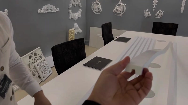 Showroom masasında poliüretan lambri panel örneği incelenirken yakın çekim