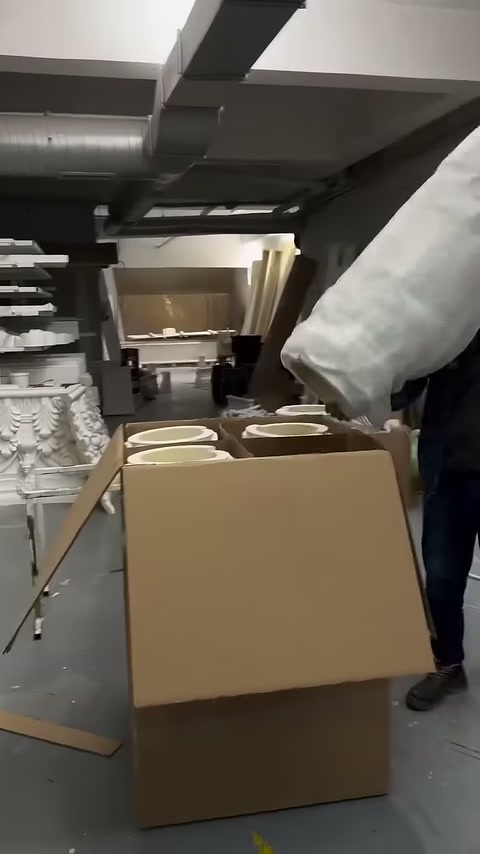 Sarılı sütun parçası açık karton kutuya doğru taşınıyor