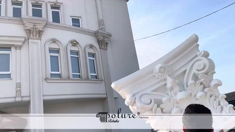 İşlemeli sütun başlığı önünde çok katlı bina cephesi