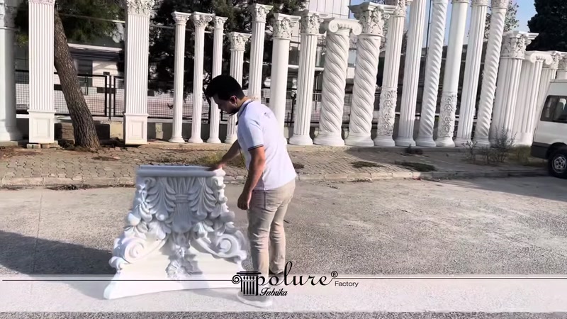 Beyaz poliüretan sütun başlığı açık alanda zeminde inceleniyor