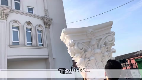 Klasik motifli sütun başlığı bina cephesi önünde tanıtılıyor
