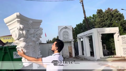 Geniş korint başlık açık alanda iki elle yukarı kaldırılıyor