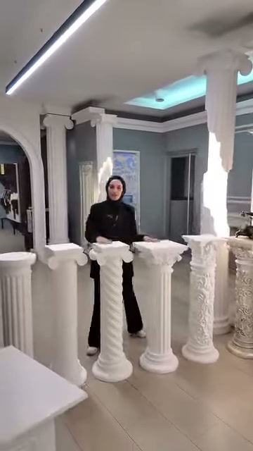 Sunucu, kare üstlü kaidelerden oluşan ürün sırasını tanıtıyor.
