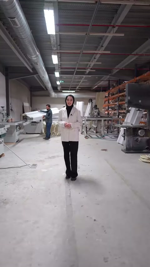 Sunucu, üretim makineleri ve profil stokları bulunan atölyede konuşuyor.