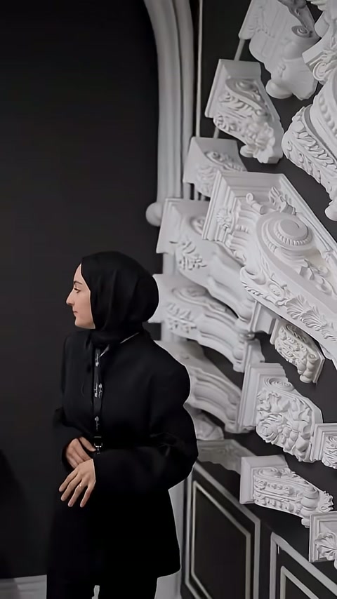 Sunucu, yatay yerleştirilmiş büyük dekoratif parçaya doğru elini uzatıyor