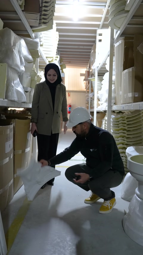 Üretici yerdeki büyük dekoratif parçayı incelemek için eğiliyor